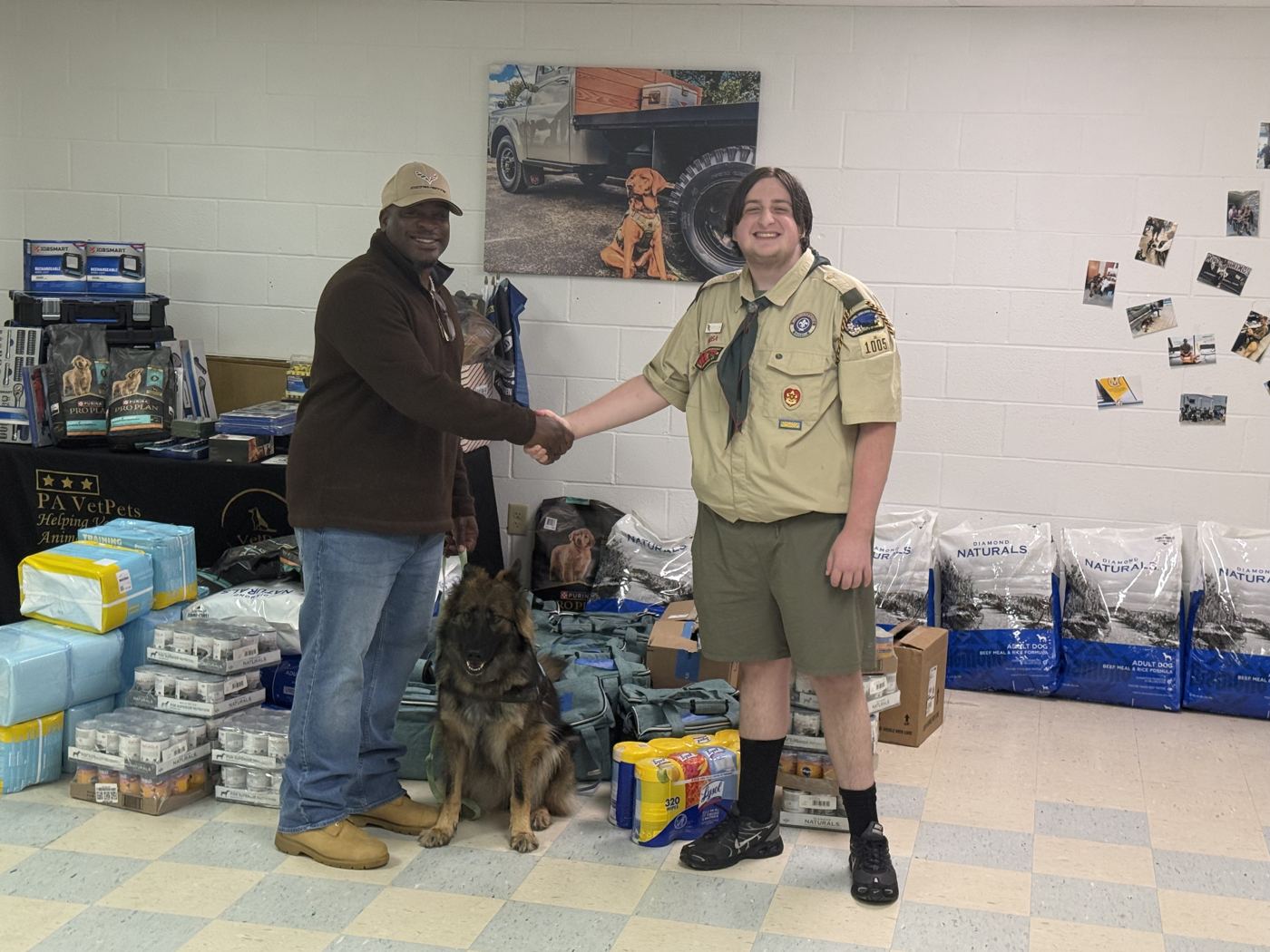 Patrick shaking hands with VetPets in front of the delivered supplies