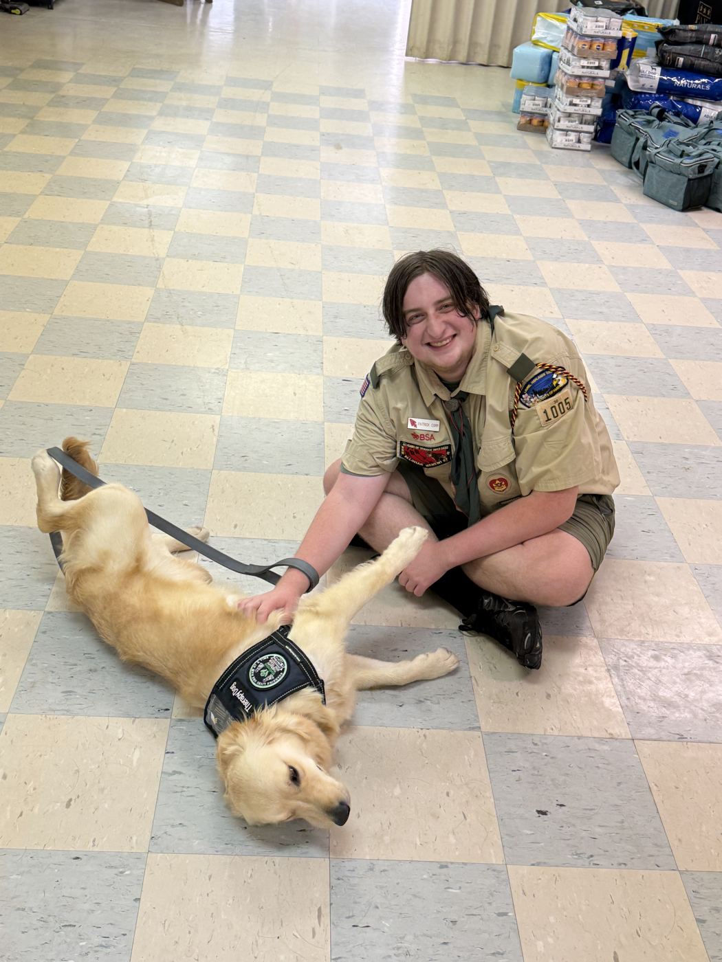Patrick sitting on the floor with a VetPets service dog