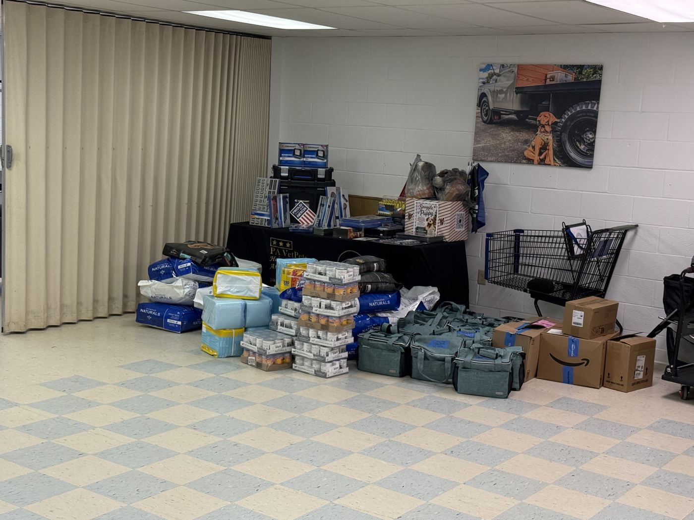 Dog food, pee pads, canned food and travel backpacks stacked inside VetPets